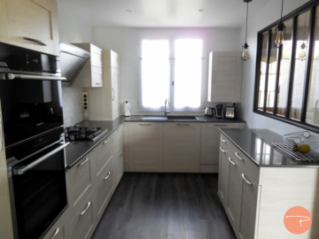 Photo d'une cuisine avec verrière, mobilier bois clair, plan de travail pierre gris anthracite, parquet gris foncé, crédence carrelage métro