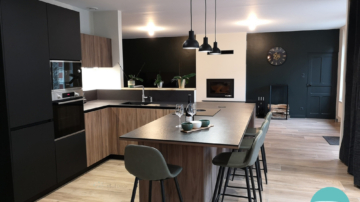 Photo d'une cuisine bois et noir avec cheminée blanche et mur vert foncé