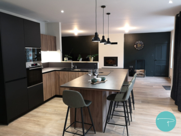 Photo d'une cuisine bois et noir avec cheminée blanche et mur vert foncé