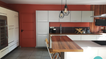 Photo après un conseil couleur d'une cuisine blanc, grise et plan de travail bois avec murs terracotta et carrelage gris