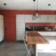 Photo après un conseil couleur d'une cuisine blanc, grise et plan de travail bois avec murs terracotta et carrelage gris