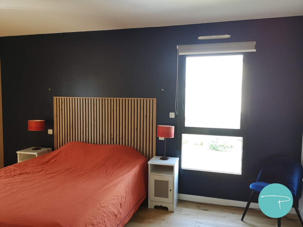 Photo après un conseil couleur d'une chambre parentale avec tête de lit bleu marine et murs jaune ocre