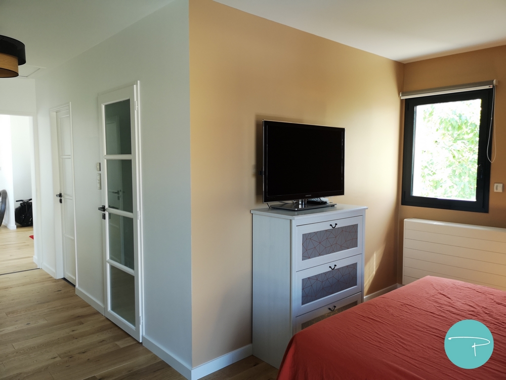 Photo après un conseil couleur d'une chambre parentale avec tête de lit bleu marine et murs jaune ocre