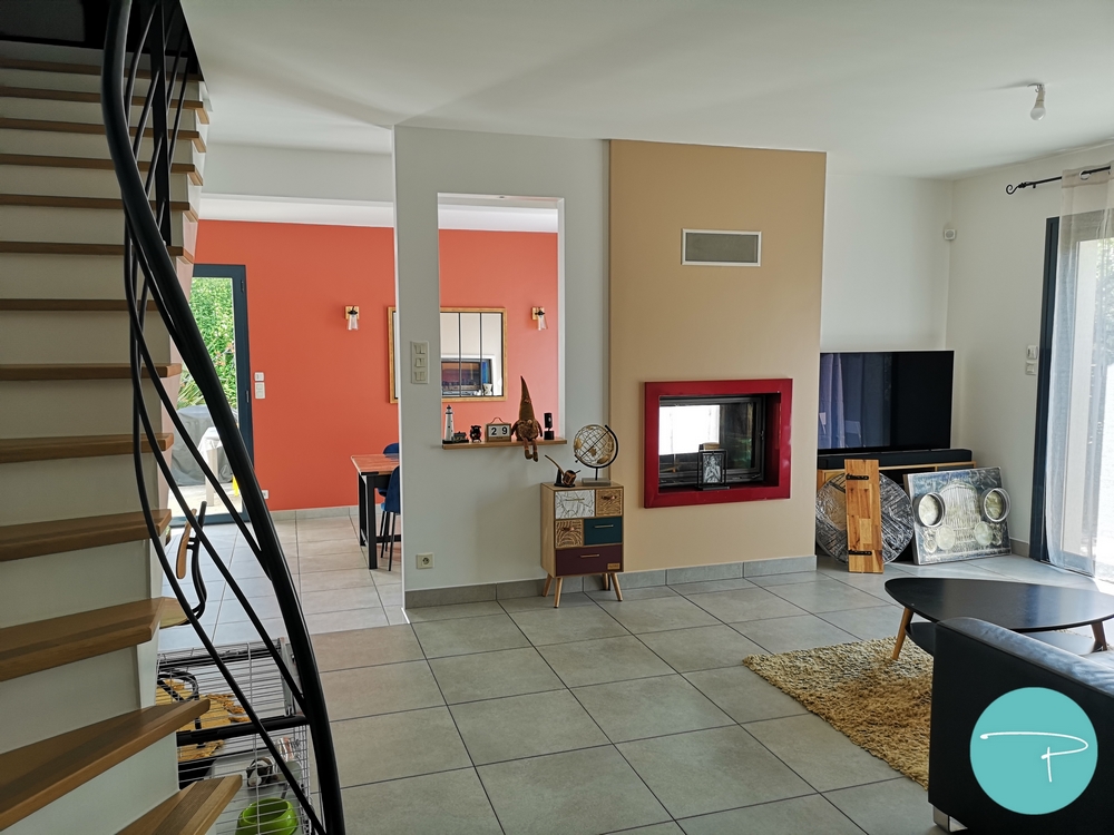 Photo après un conseil couleur d'un salle à manger avec mur terracotta et cheminée double foyer beige