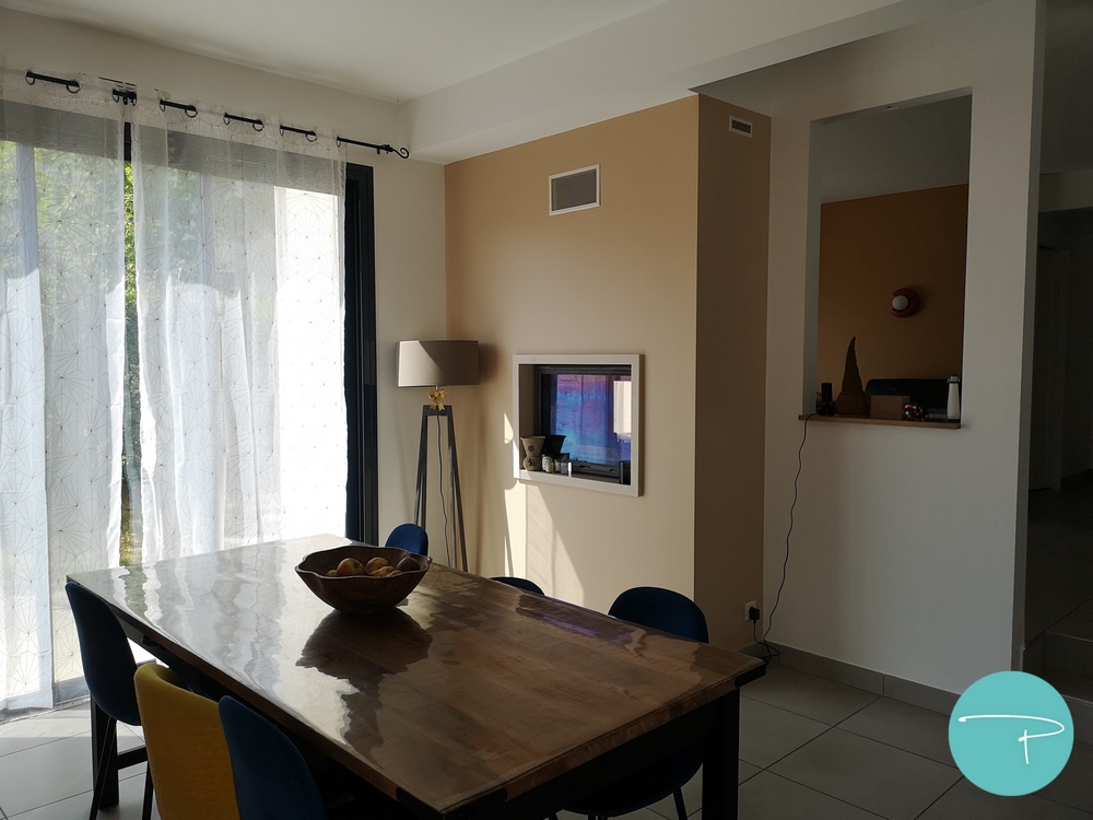 Photo après un conseil couleur d'un salle à manger avec cheminée double foyer beige