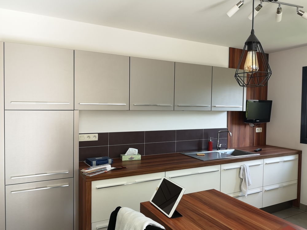 Photo avant d'une cuisine blanche et grise en travaux avec plan de travail en bois 