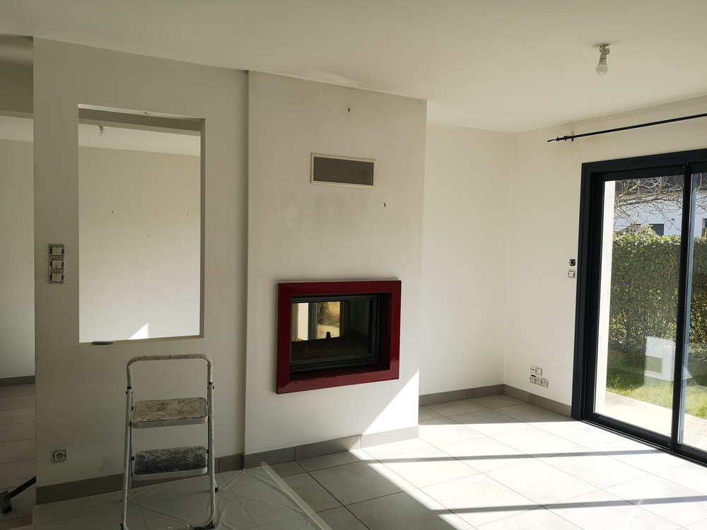 Photo avant d'un salon en travaux avec cheminée et carrelage gris