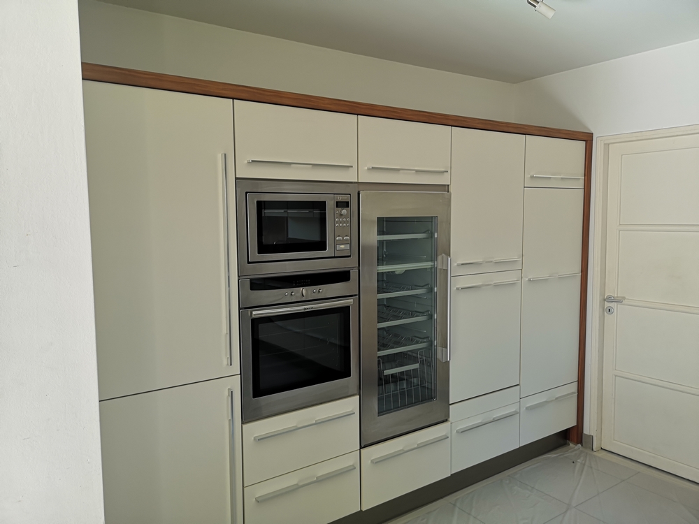 Photo avant d'une cuisine blanche et grise en travaux avec plan de travail en bois 