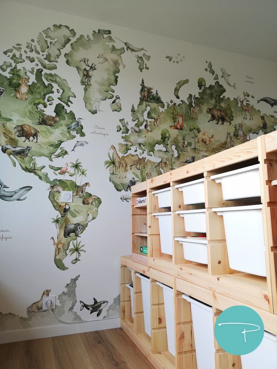 Chambre d’enfant décorée à Vitré autour d’une mappemonde panoramique illustrée. Une ambiance douce, naturelle et ludique, avec du mobilier en bois clair, des rangements pratiques et un univers inspiré du voyage, pensé pour stimuler l’imaginaire tout en conservant une pièce lumineuse et évolutive.