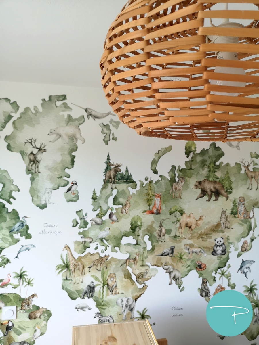 Chambre d’enfant décorée à Vitré autour d’une mappemonde panoramique illustrée. Une ambiance douce, naturelle et ludique, avec du mobilier en bois clair, des rangements pratiques et un univers inspiré du voyage, pensé pour stimuler l’imaginaire tout en conservant une pièce lumineuse et évolutive.
