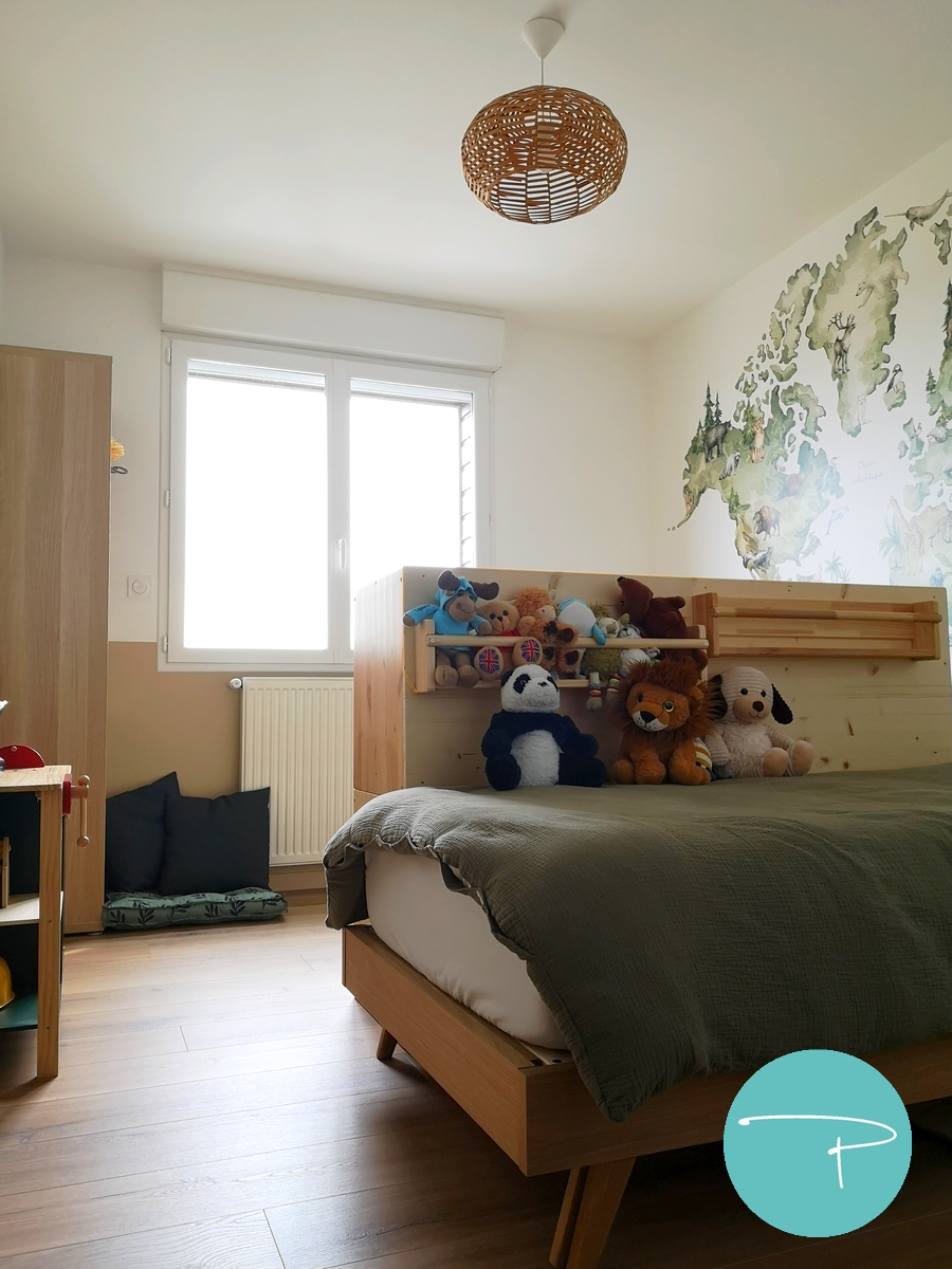 Chambre d’enfant décorée à Vitré autour d’une mappemonde panoramique illustrée. Une ambiance douce, naturelle et ludique, avec du mobilier en bois clair, des rangements pratiques et un univers inspiré du voyage, pensé pour stimuler l’imaginaire tout en conservant une pièce lumineuse et évolutive.